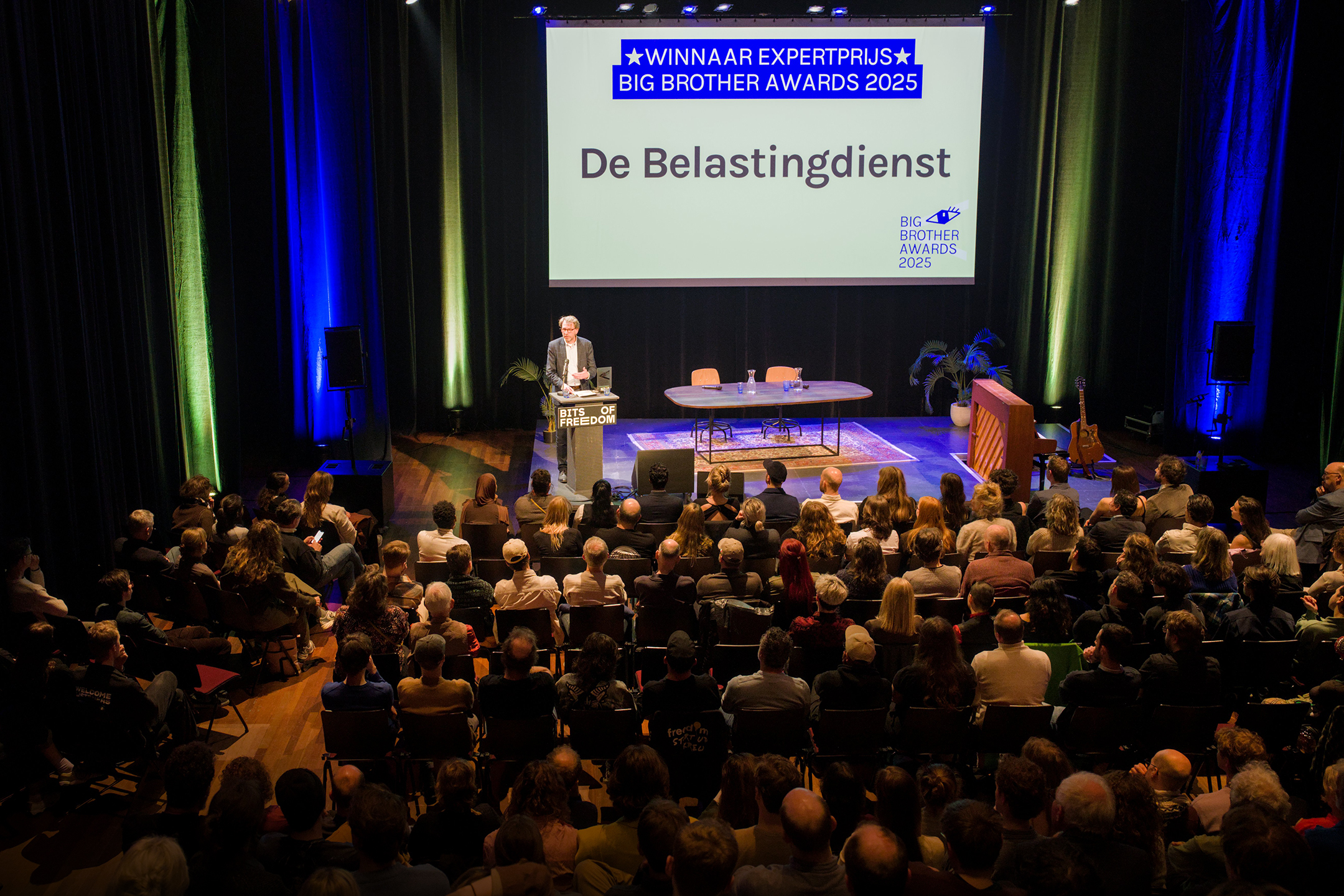 De afgezant van de Belastingdienst neemt een gewonnen Big Brother Award in ontvangst. (Foto: Bart Noordervliet)