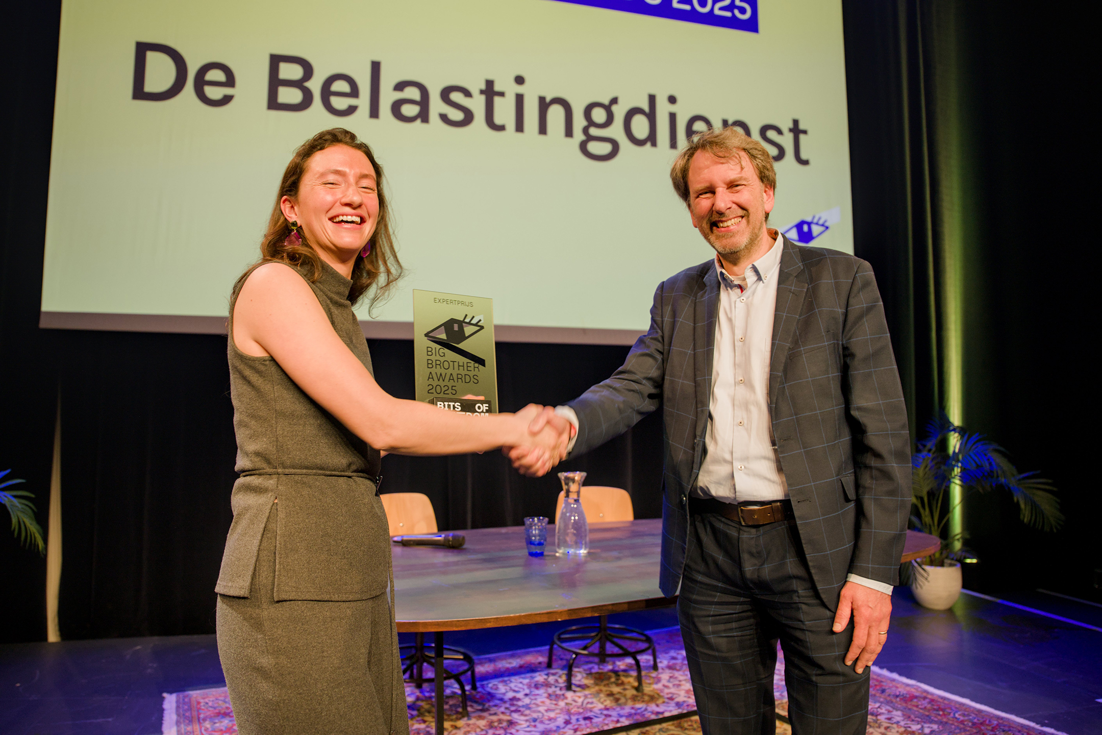 Een woordvoerder van de Belastingdienst neemt de gewonnen Big Brother Award in ontvangst.